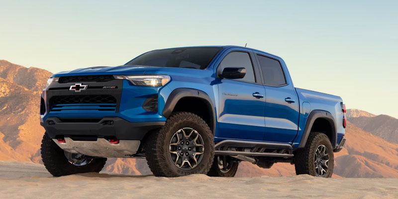 2026 Chevrolet Colorado shown on rugged desert terrain, highlighting bold styling, lifted stance, and off-road capability.