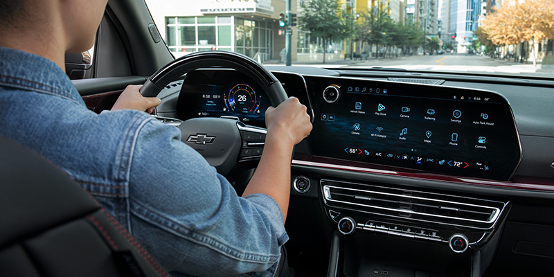 Driver using Chevrolet infotainment system and digital dashboard inside a vehicle